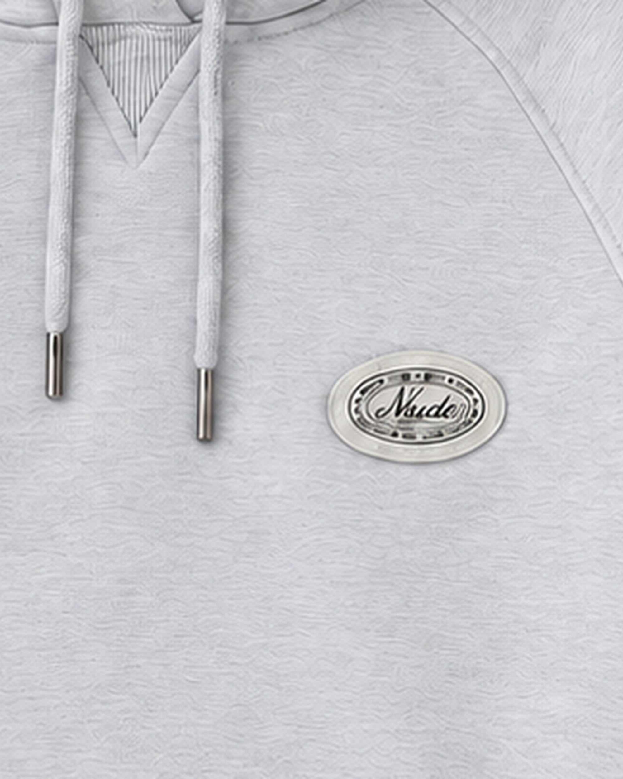 Detail crop of the oval Nude Project patch and drawcords in the grey-melange hoodie mockup.